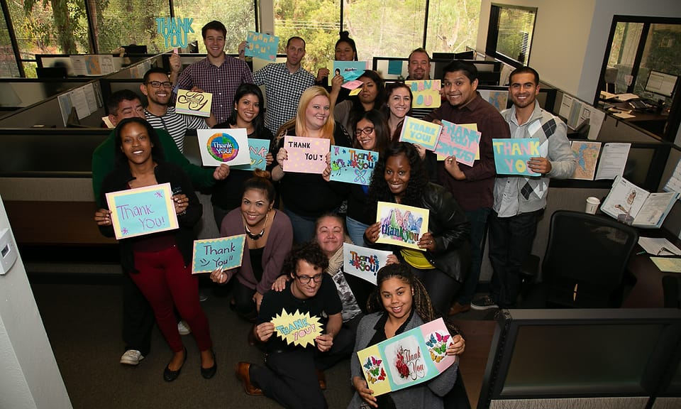 Corporate group photographed in their office cubicles during an on-site event