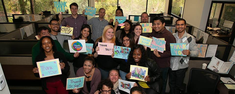 Corporate group photographed in their office cubicles during an on-site event