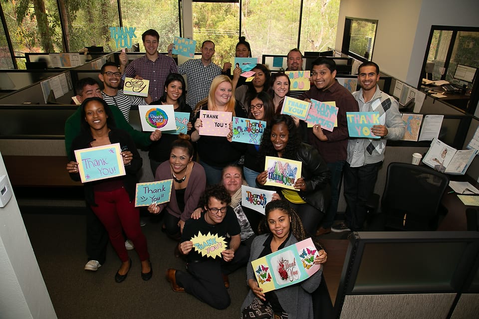 Corporate group photographed in their office cubicles during an on-site event