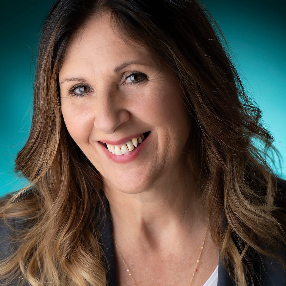 On-location business portrait against a teal backdrop set up at the workplace