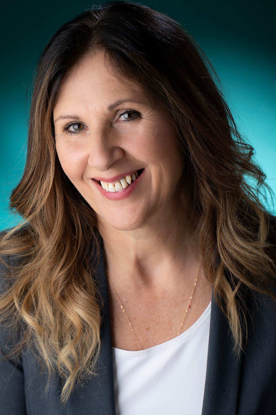 On-location business portrait against a teal backdrop set up at the workplace