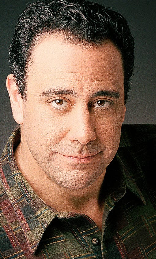 Character actor portrait of a man in a plaid shirt with a held expression