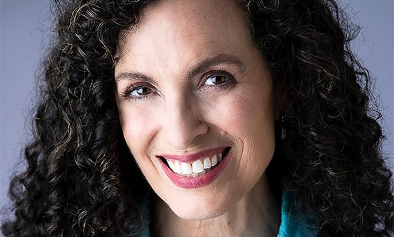 Creative professional portrait of a woman in a turquoise shirt and black blazer