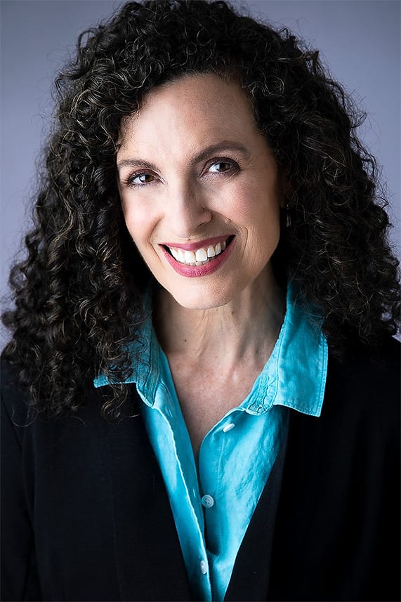 Creative professional portrait of a woman in a turquoise shirt and black blazer