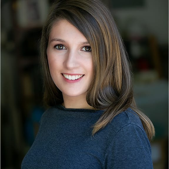 Environmental branding portrait of a woman in a blue sweater photographed indoors