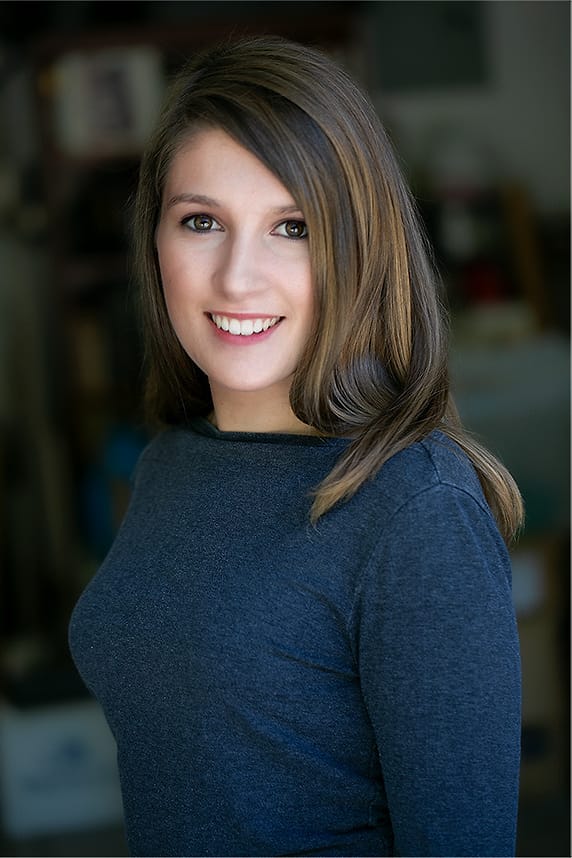 Environmental branding portrait of a woman in a blue sweater photographed indoors