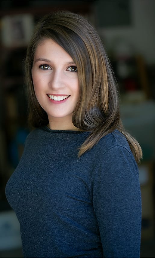 Environmental branding portrait of a woman in a blue sweater photographed indoors