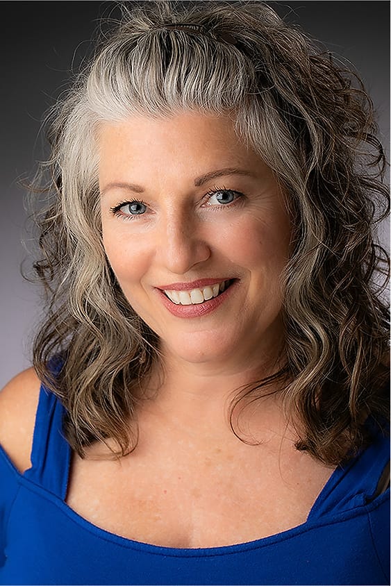 Creative portrait of a woman with gray-blonde hair in a blue off-shoulder top