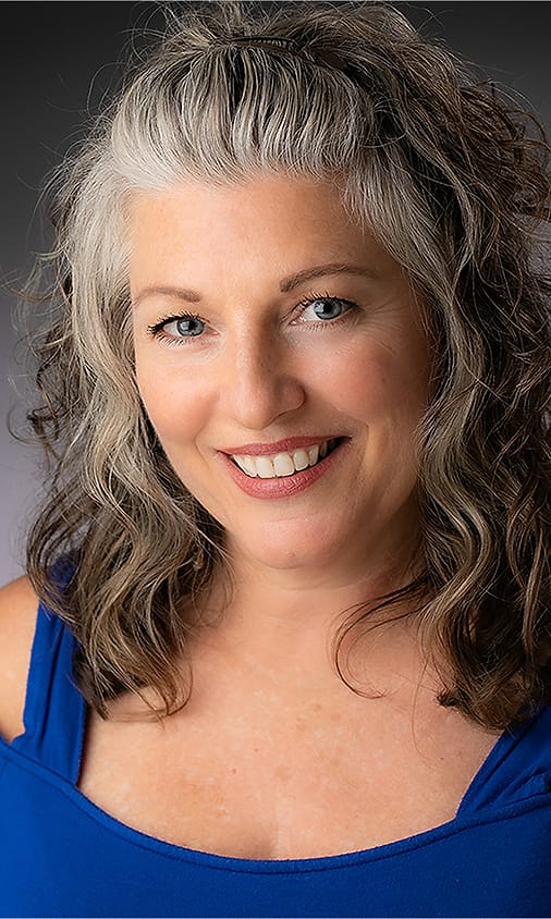 Creative portrait of a woman with gray-blonde hair in a blue off-shoulder top