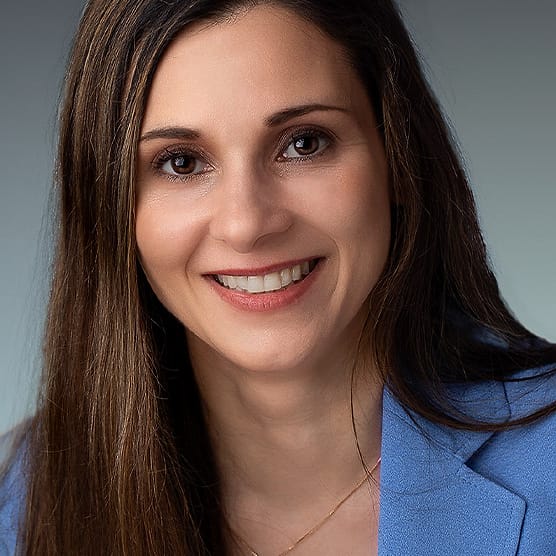 Business headshot of a woman in a blue blazer