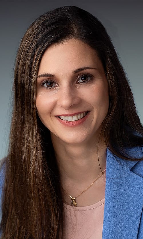 Business headshot of a woman in a blue blazer
