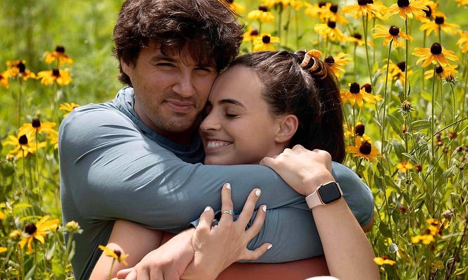 Color outdoor couple portrait in a field of black-eyed Susans in Asheville