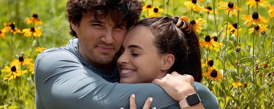 Color outdoor couple portrait in a field of black-eyed Susans in Asheville