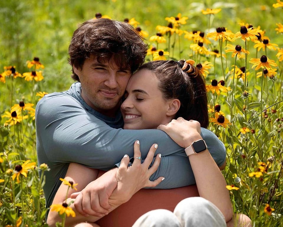 Color outdoor couple portrait in a field of black-eyed Susans in Asheville