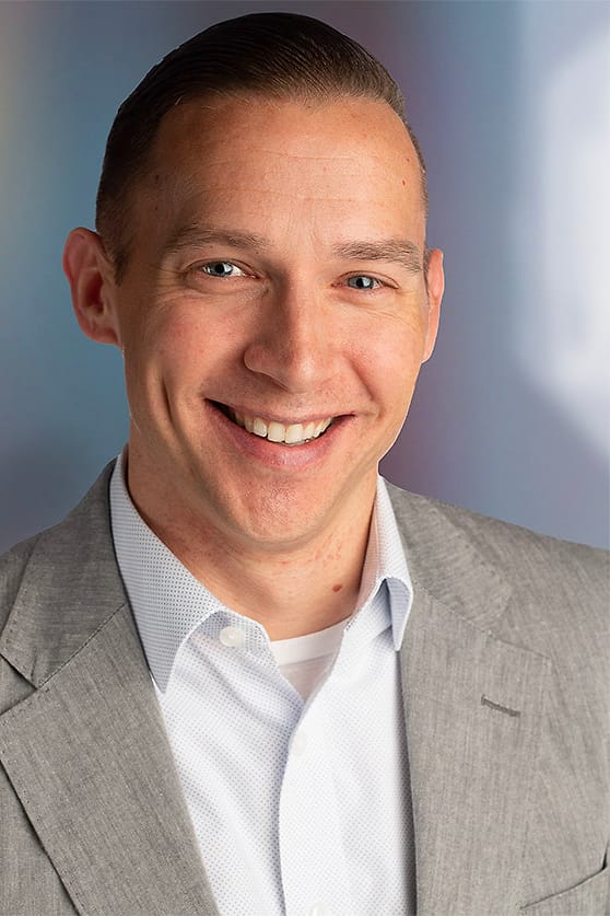 Asheville corporate headshot of a man in a gray suit and open-collar shirt
