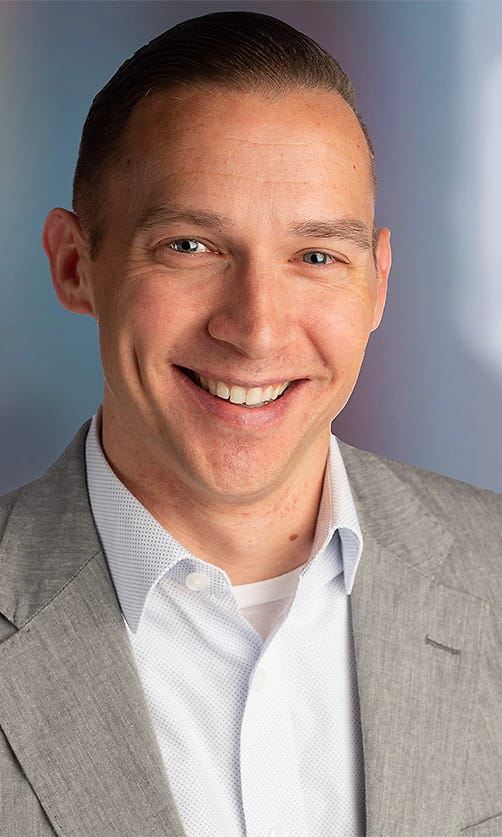 Asheville corporate headshot of a man in a gray suit and open-collar shirt