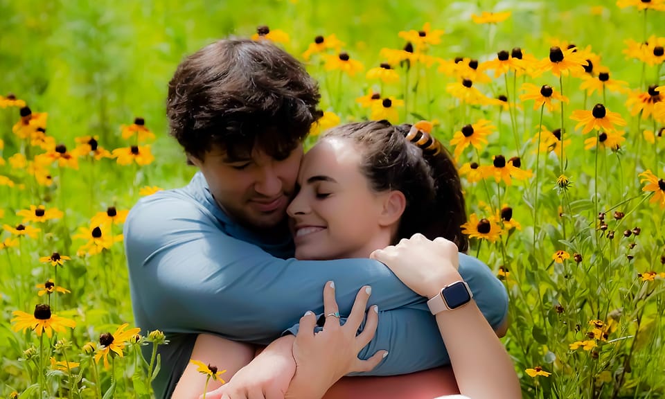 Intimate outdoor couple portrait, close hug in a field of black-eyed Susans