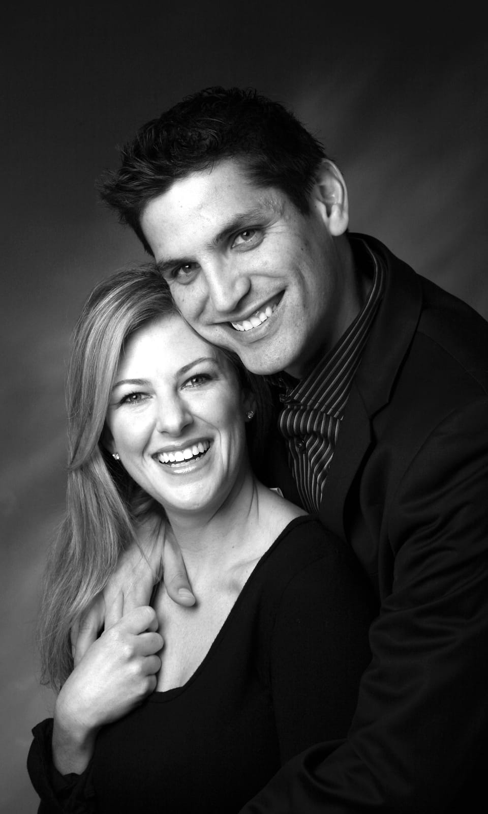 Black and white studio portrait of a couple, close and directed