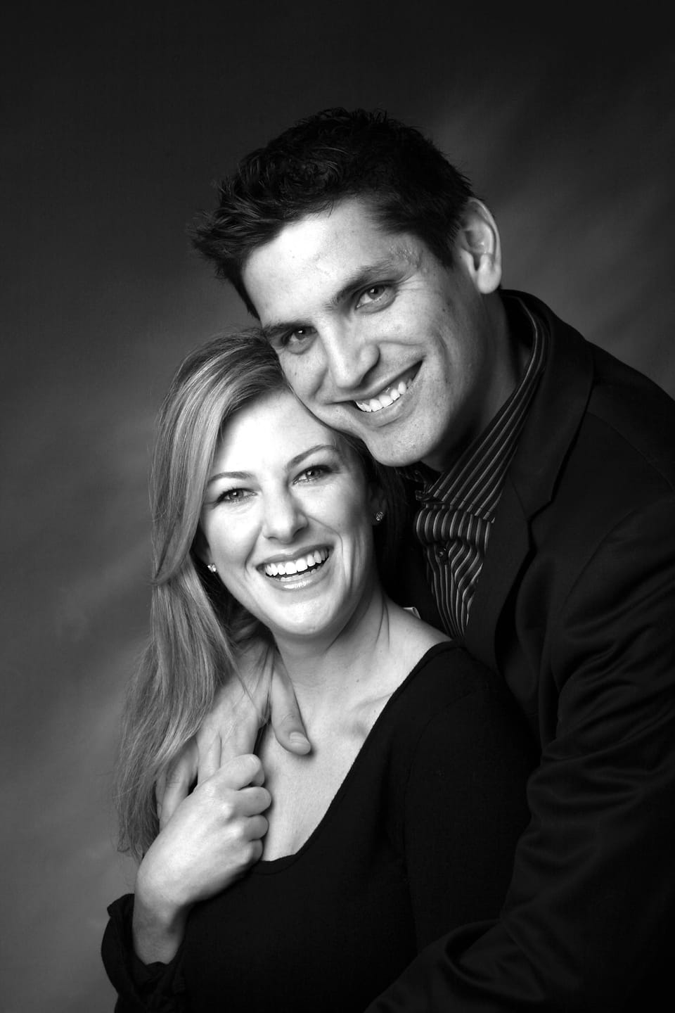 Black and white studio portrait of a couple, close and directed