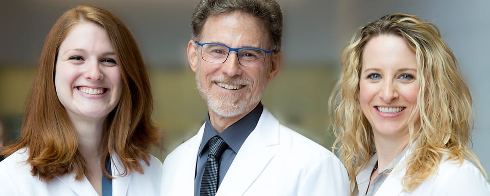 Three Strom Dental clinicians in white coats, photographed together on site